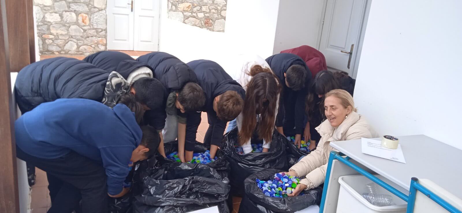 οι μαθητές/τριες, οι γονείς τους και οι εκπαιδευτικοί του Γυμνασίου Ύδρας συλλέγουν πλαστικά καπάκια